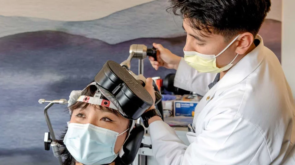 Physician using TMS machine on patient