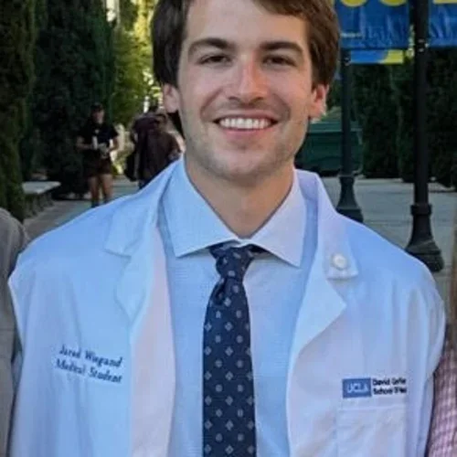 Jared Wiegand, wearing his white coat, standing outside.